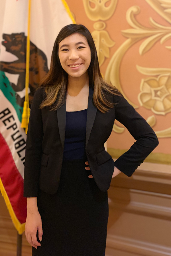 Queenie Lam standing in front of a California Flag