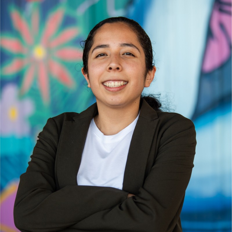 Daniela Franco young latina college student smiling with her arms folded wearing a dark blazer and white shirt