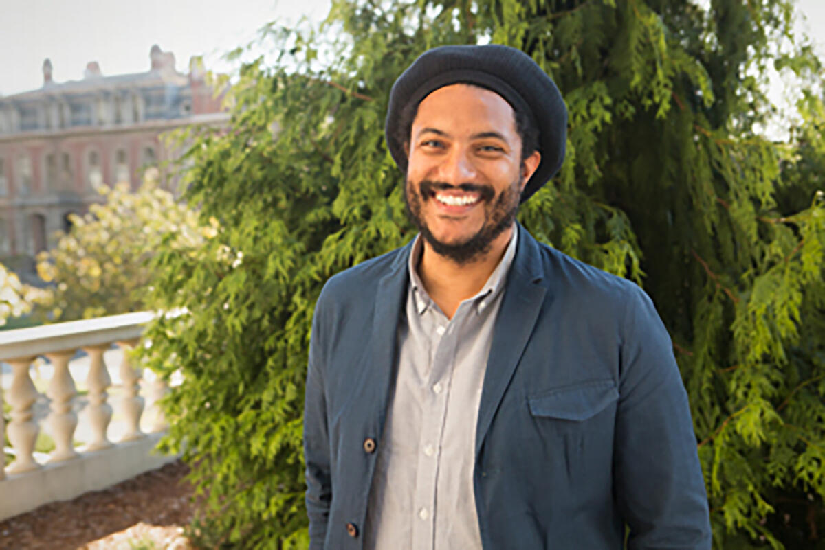 Jovan Lewis wearing a blue jacket and blue plaid buttondown shirt