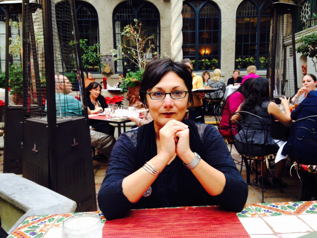 Laura E. Pérez sitting at a restaurant table in a dark top