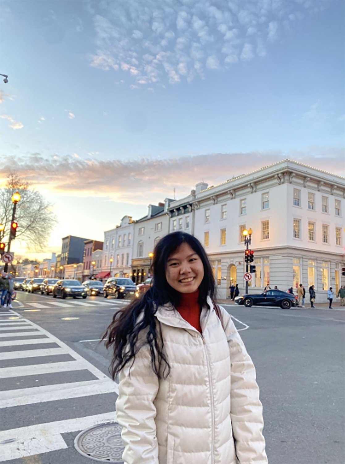 Maggie Tsao standing outside in Washington DC during sunset in a white puffer coat