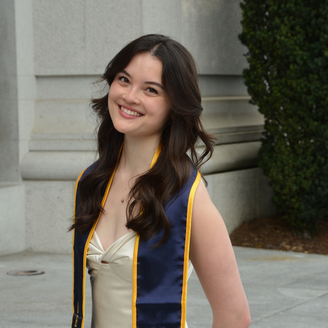 young woman UC Berkeley graduate with wavy brown hair and graduation stole