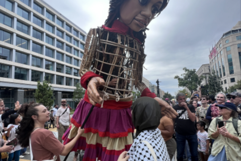 Photo of UCDC Fellow taken in Washington D.C with Little Amal, 12 foot animatronic humanitarian puppet