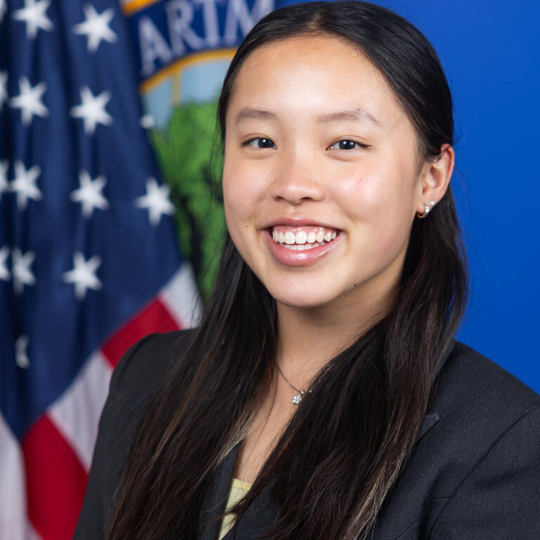 young asian woman poses in front of American flag in professional photo