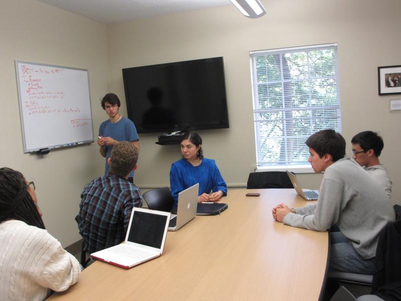 group of people sitting at a table inside the Matsui Center study room