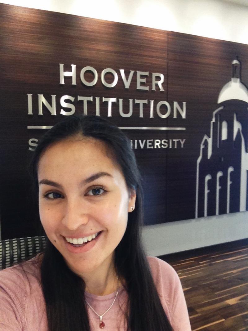 Anya Ku standing in front of Hoover Institution sign