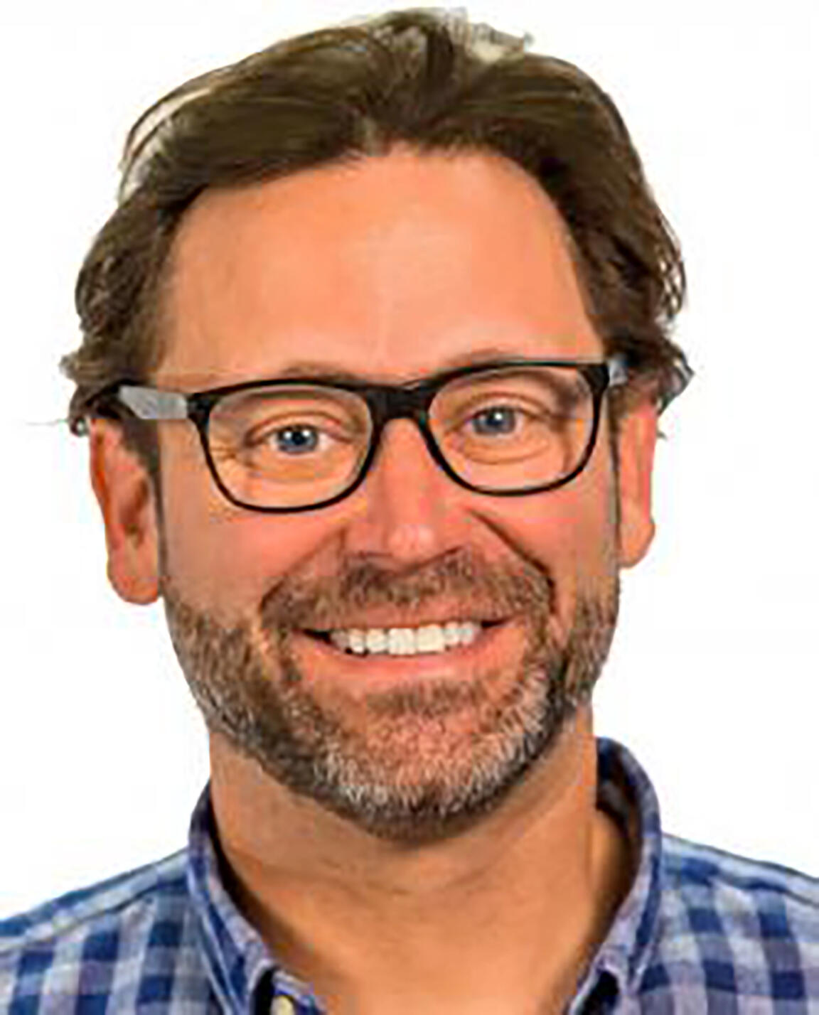 Sean Gailmard wearing glasses and smiling ub a blue plaid buttondown against a white background