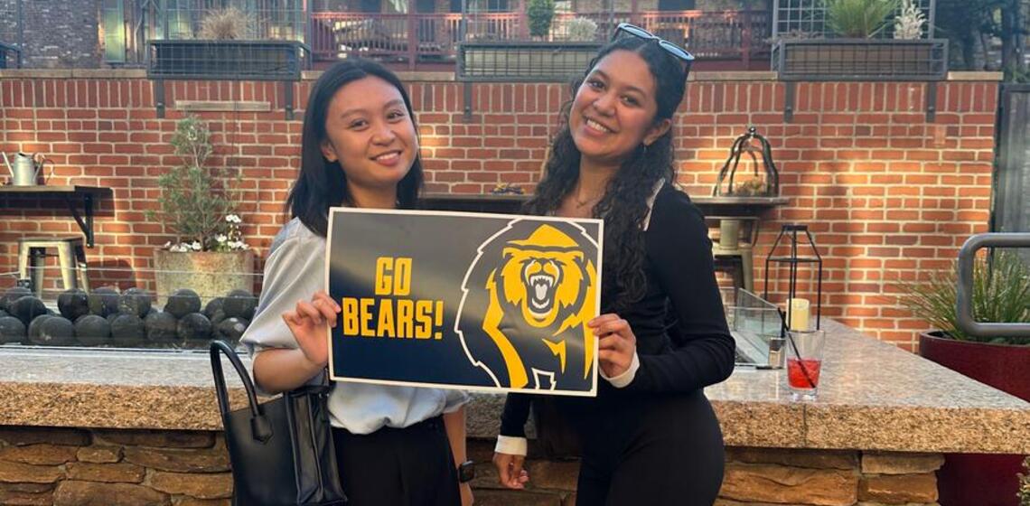 Two young women hold a sign that says Go Bears