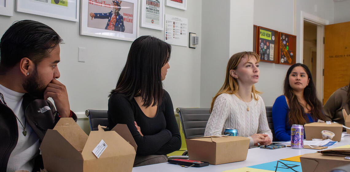 Four young people speak together at a conference table