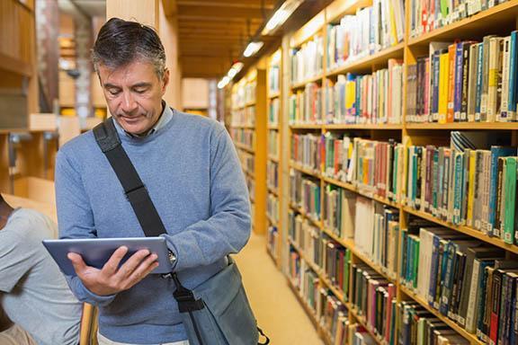 man inside a library reading a book 