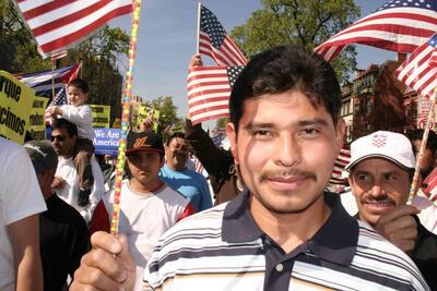 immigrant man holding an american flag while marching 