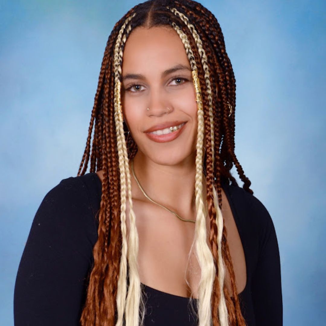 young black girl with braids in a blue background headshot