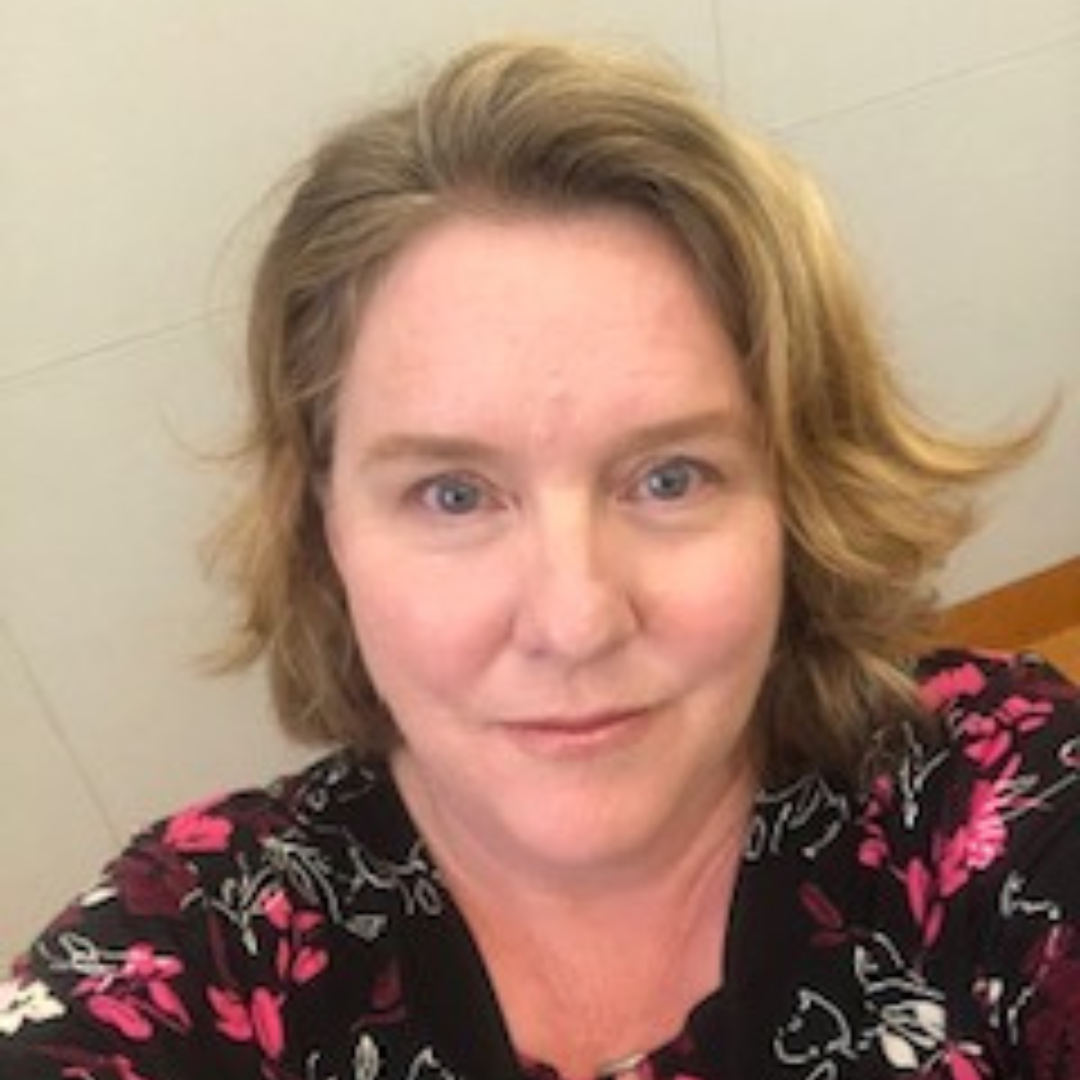 Visiting Scholar Kathleen Morris Visiting Scholar Kathleen Morris, woman with blonde chin length hair and black shirt adorned with pink, red flower patterns